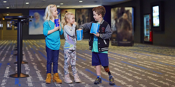 Young boy with a prosthetic leg hanging out with his friends in cinema