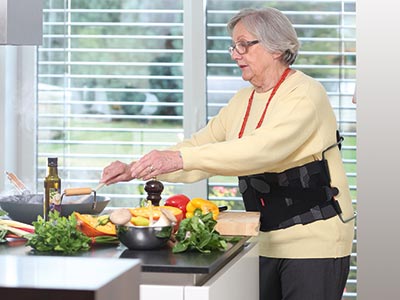 Woman cooking with orthosis