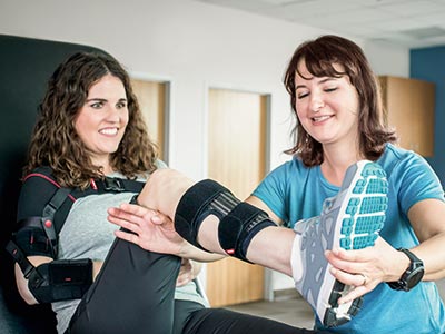 Woman excersising leg with orthosis