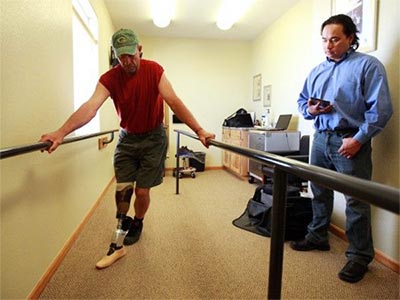 Man with a prosthetic leg excersising with prosthetist Kamil Leman