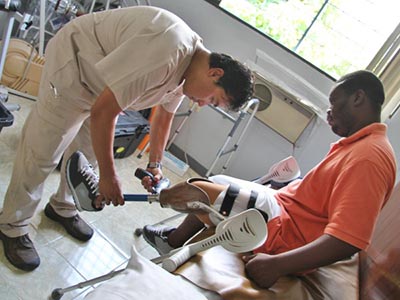 Haitan man trying on his prosthetic leg with prosthetist Kamil Leman